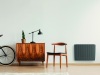 Stylish chair next to retro cabinet and vintage bike in scandinavian minimal interior with mockup on the wall and carpet on the wooden floor, real photo with copy space on the wall